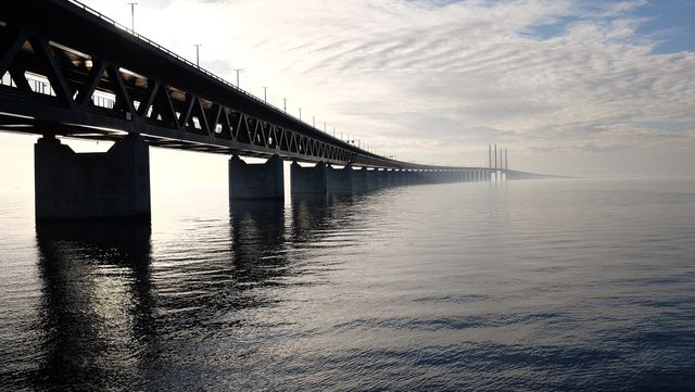 Grey Concrete Bridge on Body of Water Under Blue and White Sky during Daytime - Download Free Stock Photos Pikwizard.com