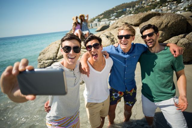 Male friends taking selfie at beach - Download Free Stock Photos Pikwizard.com