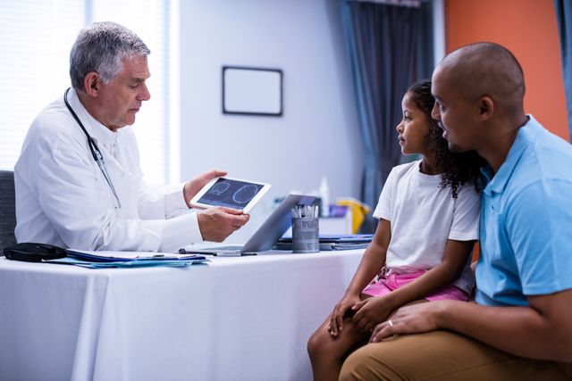 Doctor using digital tablet while interacting with patient in clinic