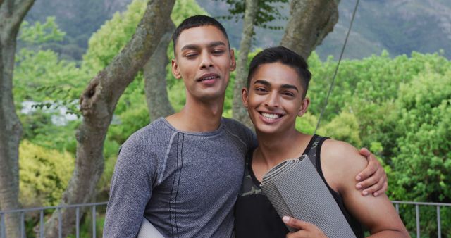 Portrait of happy mixed race gay male couple standing in garden embracing and laughing - Download Free Stock Photos Pikwizard.com
