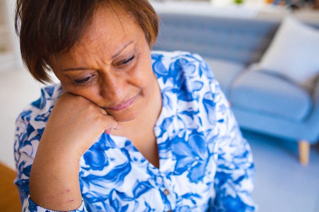 Sad african american senior woman with head in hand sitting at home - Download Free Stock Photos Pikwizard.com