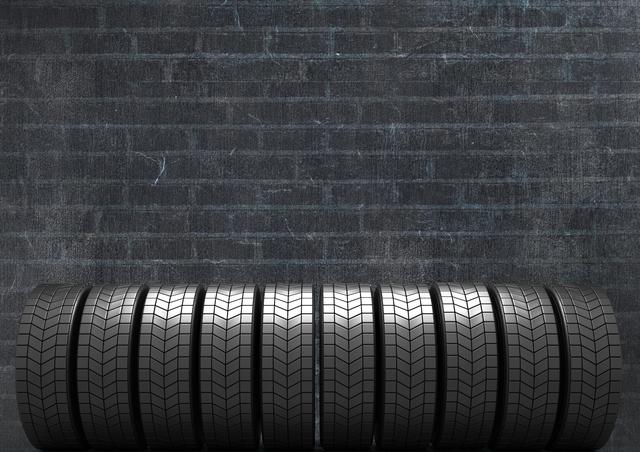 Digital composition of stack of tyres against black brick background