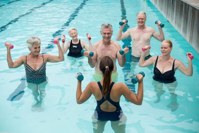 Trainer and senior swimmers exercising in swimming pool- Download Free Stock Photos Pikwizard.com