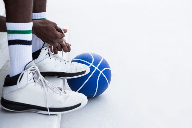 Low section basketball player tying shoelace