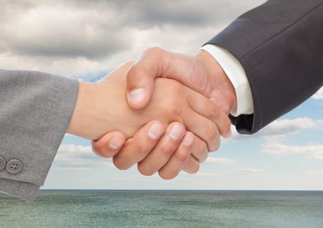 Businesspeople shaking hands against sea and clouds - Download Free Stock Photos Pikwizard.com