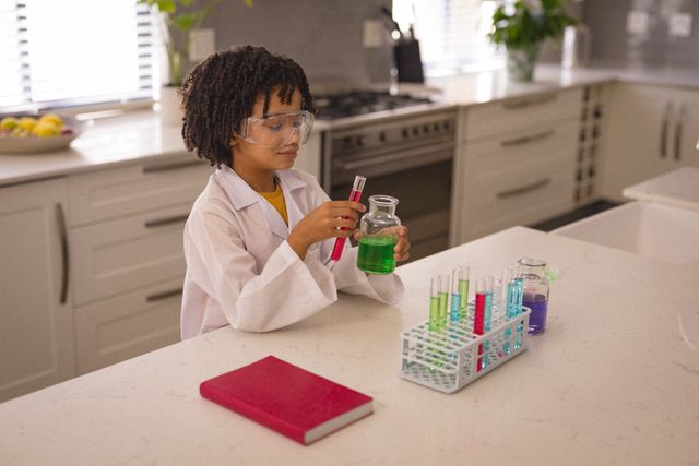 Hispanic boy mixing chemical solution in test tube and beaker at home. unaltered, childhood, science experiment, discovery and learning concept.