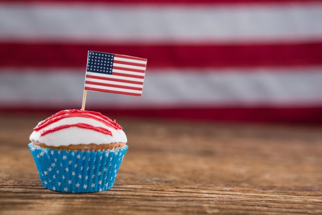 Close-up of patriotic cupcake with American flag on wooden table