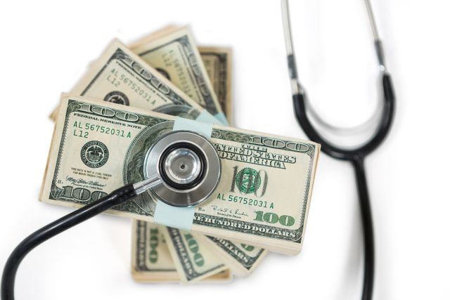 Stethoscope on bundle of currency note - Download Free Stock Photos Pikwizard.com