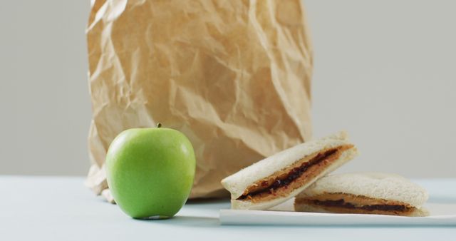 Lunch box with sandwich and apple on white background