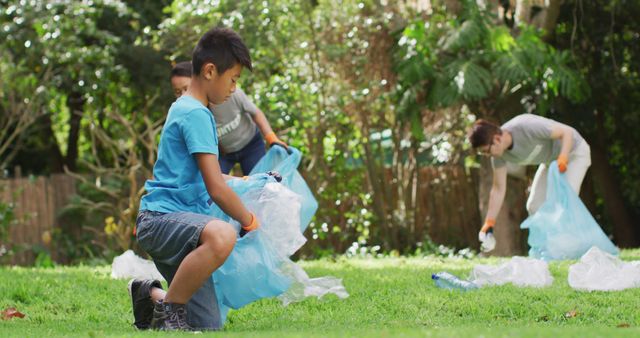 Asian son holding refuse sack, collecting plastic waste outdoors with mother and father. eco conservation volunteers doing countryside clean-up.