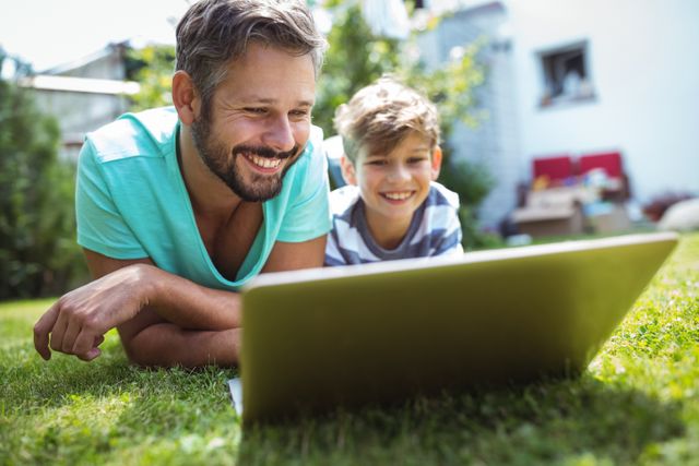 Father and son using laptop in garden - Download Free Stock Photos Pikwizard.com