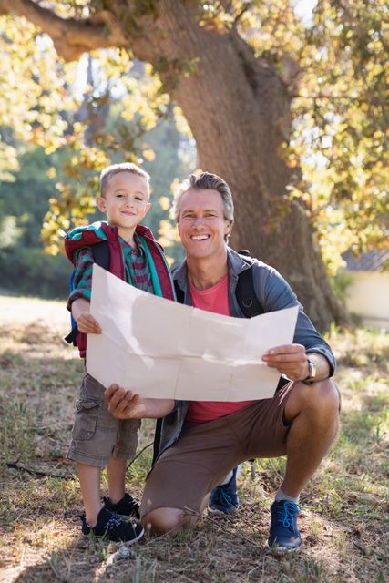Portrait of happy father and son with map - Download Free Stock Photos Pikwizard.com