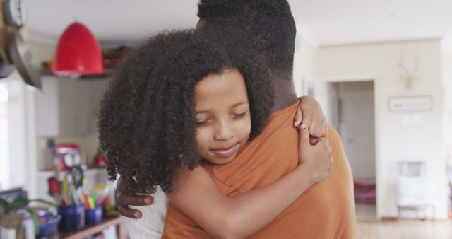 Smiling african american daughter hugging father in kitchen - Download Free Stock Photos Pikwizard.com
