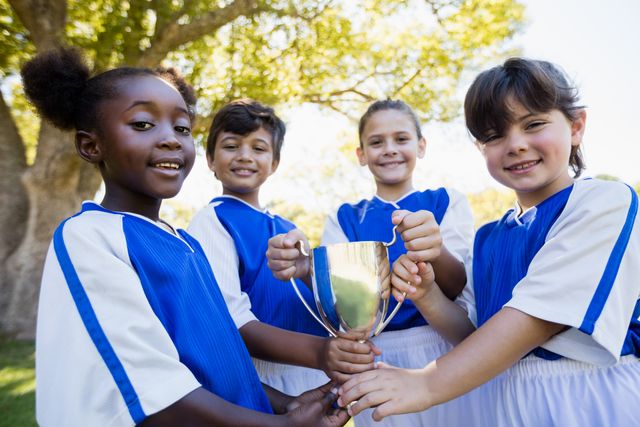 Happy children soccer team holding cup- Download Free Stock Photos Pikwizard.com
