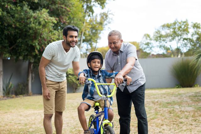 Father and grandfather assisting boy for riding bicycle - Download Free Stock Photos Pikwizard.com