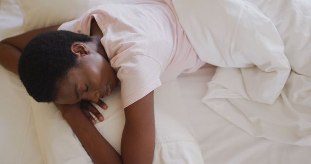 African american woman sleeping and wearing white pyjamas in her bedroom. health and beauty concept.