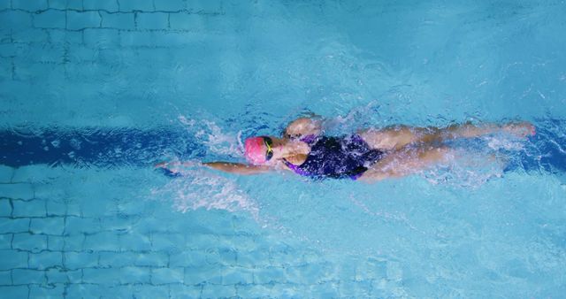 Caucasian woman swims in a pool, showcasing her athletic form from ...