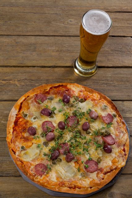 Delicious pizza served on pizza tray with a glass of beer - Download Free Stock Photos Pikwizard.com