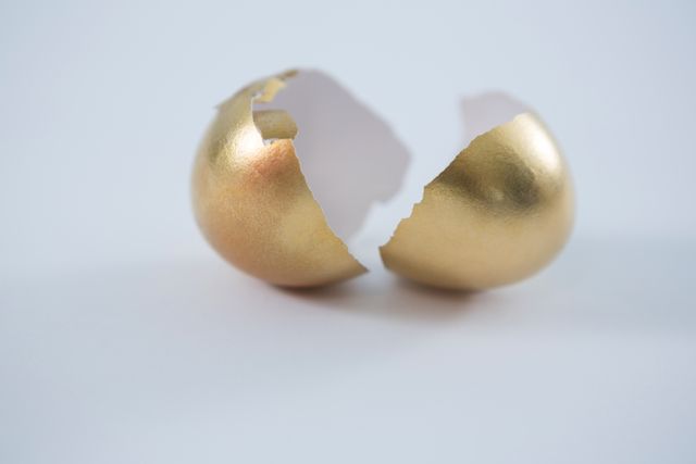 Broken golden Easter egg on white background - Download Free Stock Photos Pikwizard.com