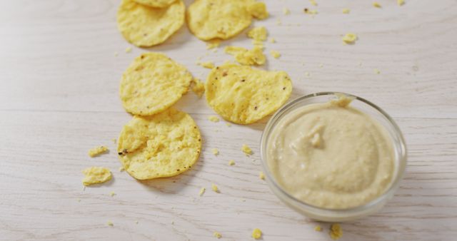 Image of crisps and cheese dip on a wooden surface. party food and savoury snacks.