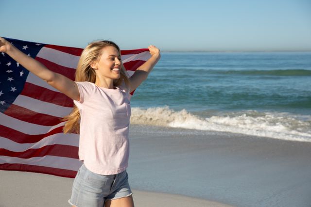 Woman holding American flag at the beach - Download Free Stock Photos Pikwizard.com