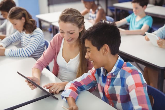 Students using digital tablet in classroom at school