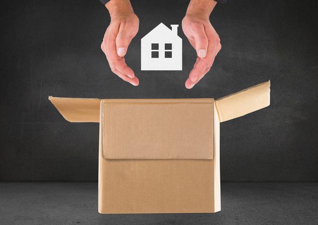 Man hand protecting house over cardboard box against black background - Download Free Stock Photos Pikwizard.com