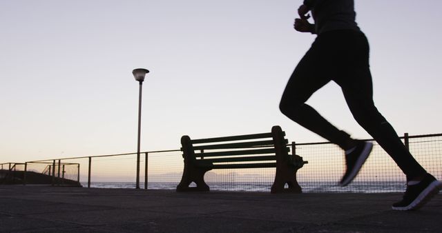 African american man exercising outdoors, running by seaside in the evening. fitness, active and healthy lifestyle concept.