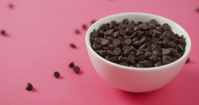 Image of bowl of chocolate chip over pink background. fusion food, chocolate and sweets concept.
