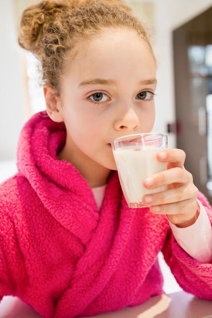 Cute girl drinking milk in kitchen - Download Free Stock Photos Pikwizard.com