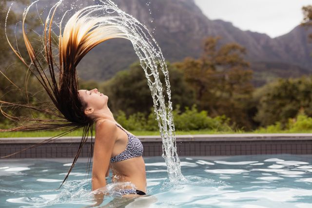 Woman flipping her hair in swimming pool - Download Free Stock Photos Pikwizard.com