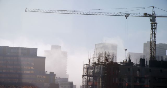 A misty construction site with a crane and buildings illustrates urban growth with mystery. - Download Free Stock Photos Pikwizard.com