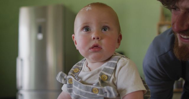 Portrait of happy caucasian baby looking at camera in kitchen - Download Free Stock Photos Pikwizard.com