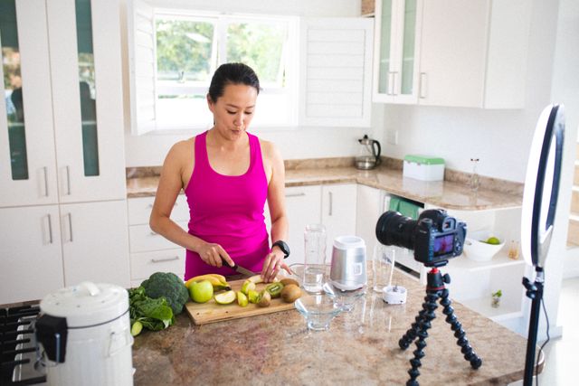 Asian woman vlogging while cutting fruits to make healthy juice at home - Download Free Stock Photos Pikwizard.com