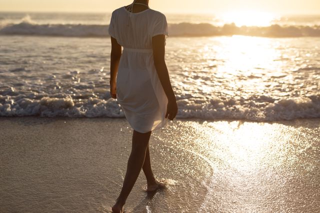 Woman walking towards sea on the beach - Download Free Stock Photos Pikwizard.com