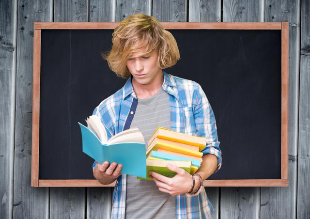 Teenage student reading books against blackboard - Download Free Stock Photos Pikwizard.com