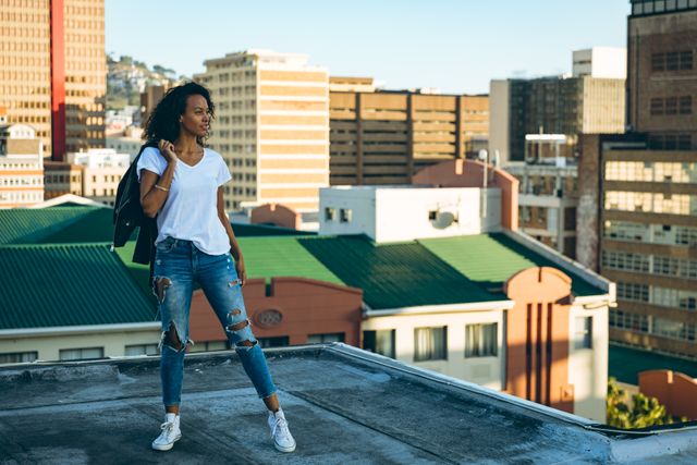 Young mixed race woman standing on an urban rooftop - Download Free Stock Photos Pikwizard.com