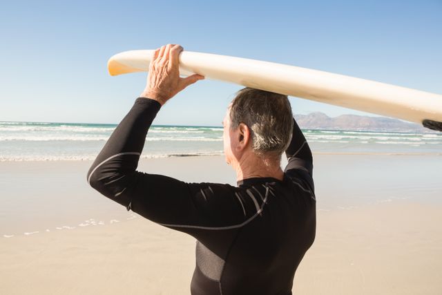 Rear view of man carrying surfboard - Download Free Stock Photos Pikwizard.com