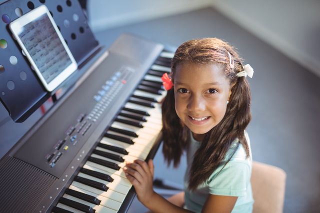 Portrait of elementary girl practicing piano in class at school