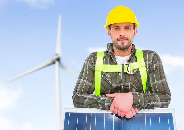 Handyman standing with solar panel and wind turbine in background - Download Free Stock Photos Pikwizard.com