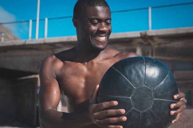 Portrait of smiling african american man exercising with weights on sunny day - Download Free Stock Photos Pikwizard.com