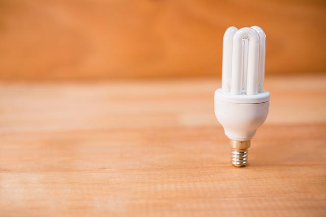 Close-up of energy saving bulb on a wooden floor
