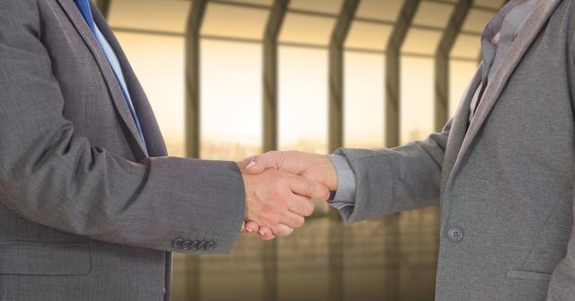 Digital composite of Midsection of businessmen shaking hands in office