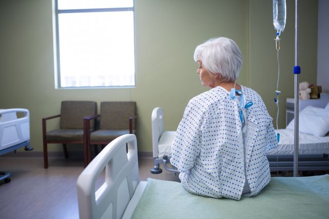 Rear-view of thoughtful senior patient sitting on bed - Download Free Stock Photos Pikwizard.com