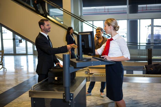 Female staff interacting with passenger at the airport terminal