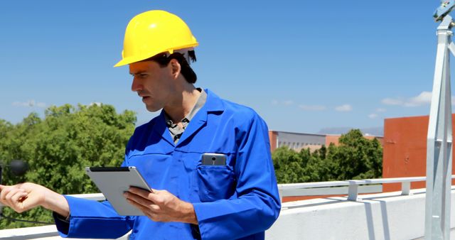 Young Caucasian man in blue workwear inspects a construction site - Download Free Stock Photos Pikwizard.com