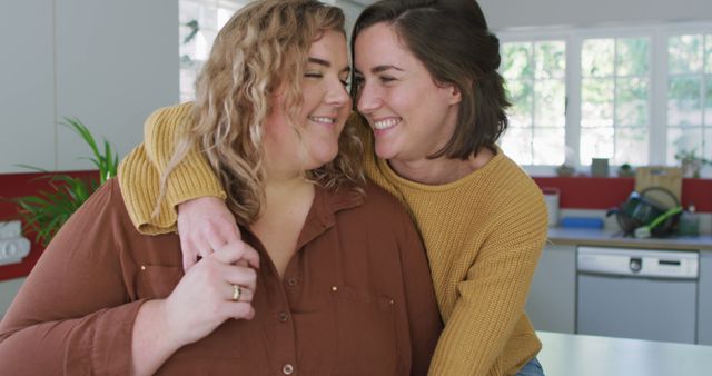 Portrait of caucasian lesbian couple embracing and smiling. domestic life, spending free time relaxing at home.