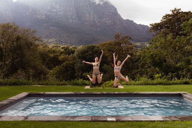 Female friends jumping in swimming pool at backyard - Download Free Stock Photos Pikwizard.com