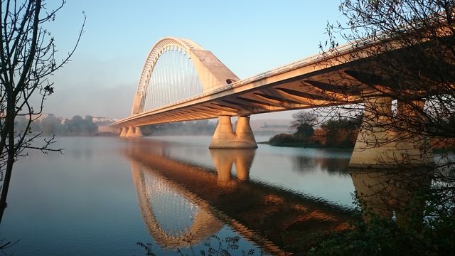 Grey Concrete Bridge Above Water Under Blue Sky - Download Free Stock Photos Pikwizard.com