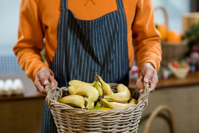 Vendor holding a basket of bananas - Download Free Stock Photos Pikwizard.com